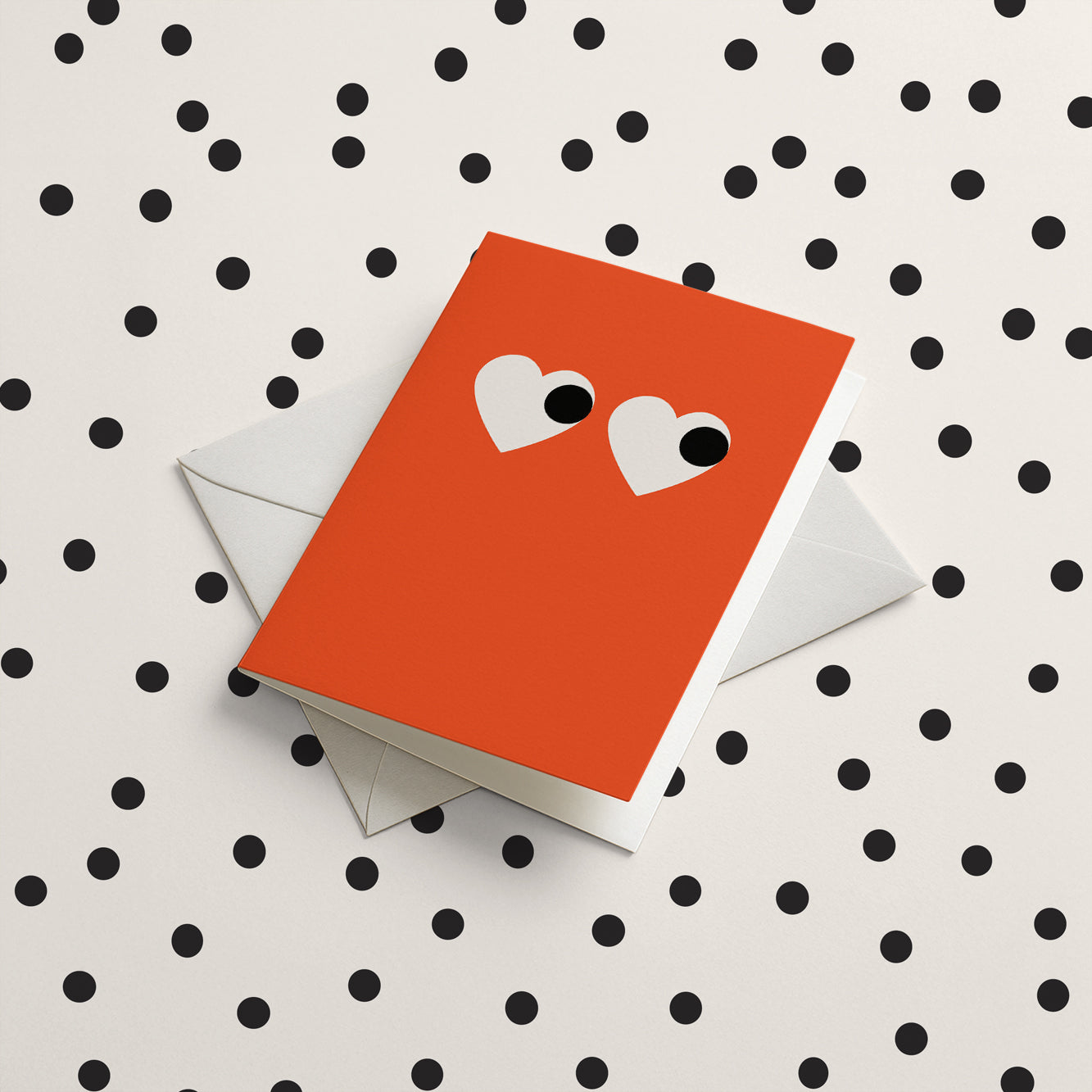 Red greeting card with white heart eyes on a polka dot background