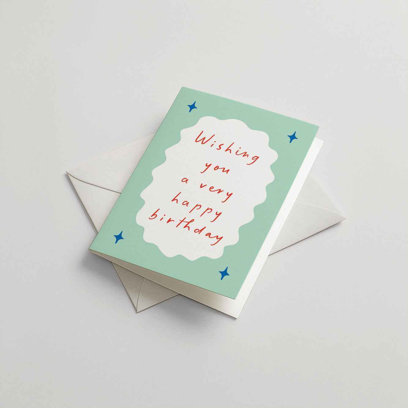 Greeting card with 'Wishing you a very happy birthday' text on a light green background with blue stars, accompanied by an envelope.
