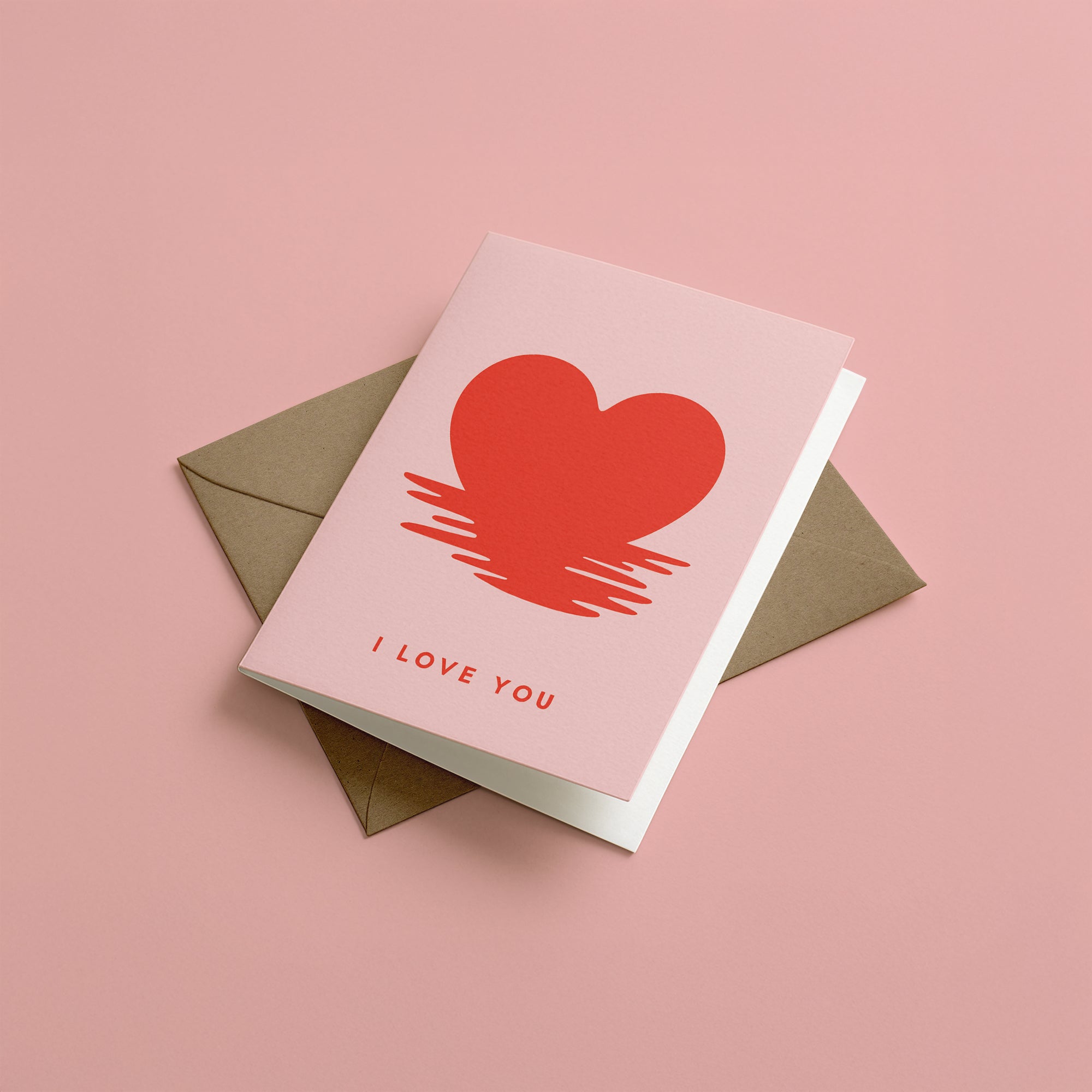 Greeting card with red heart and 'I LOVE YOU' text on a pink background