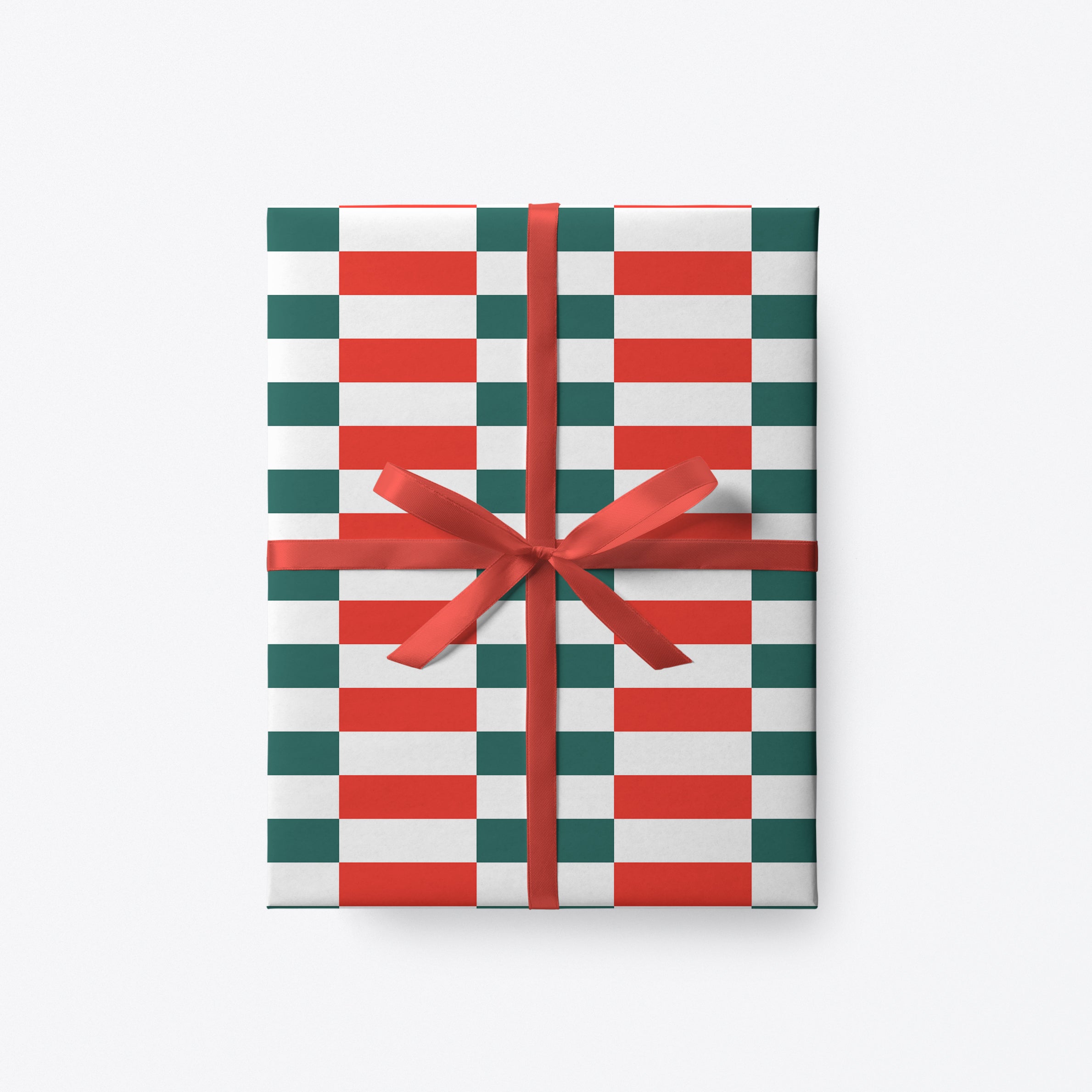 Modern Christmas wrapping paper with red, green and white stripe pattern tied with red ribbon.
