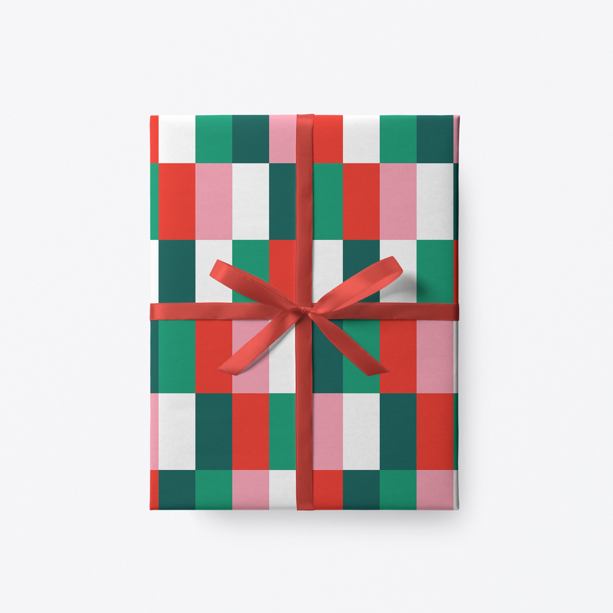 Modern chequered Christmas wrapping paper in red, green and pink with red ribbon.