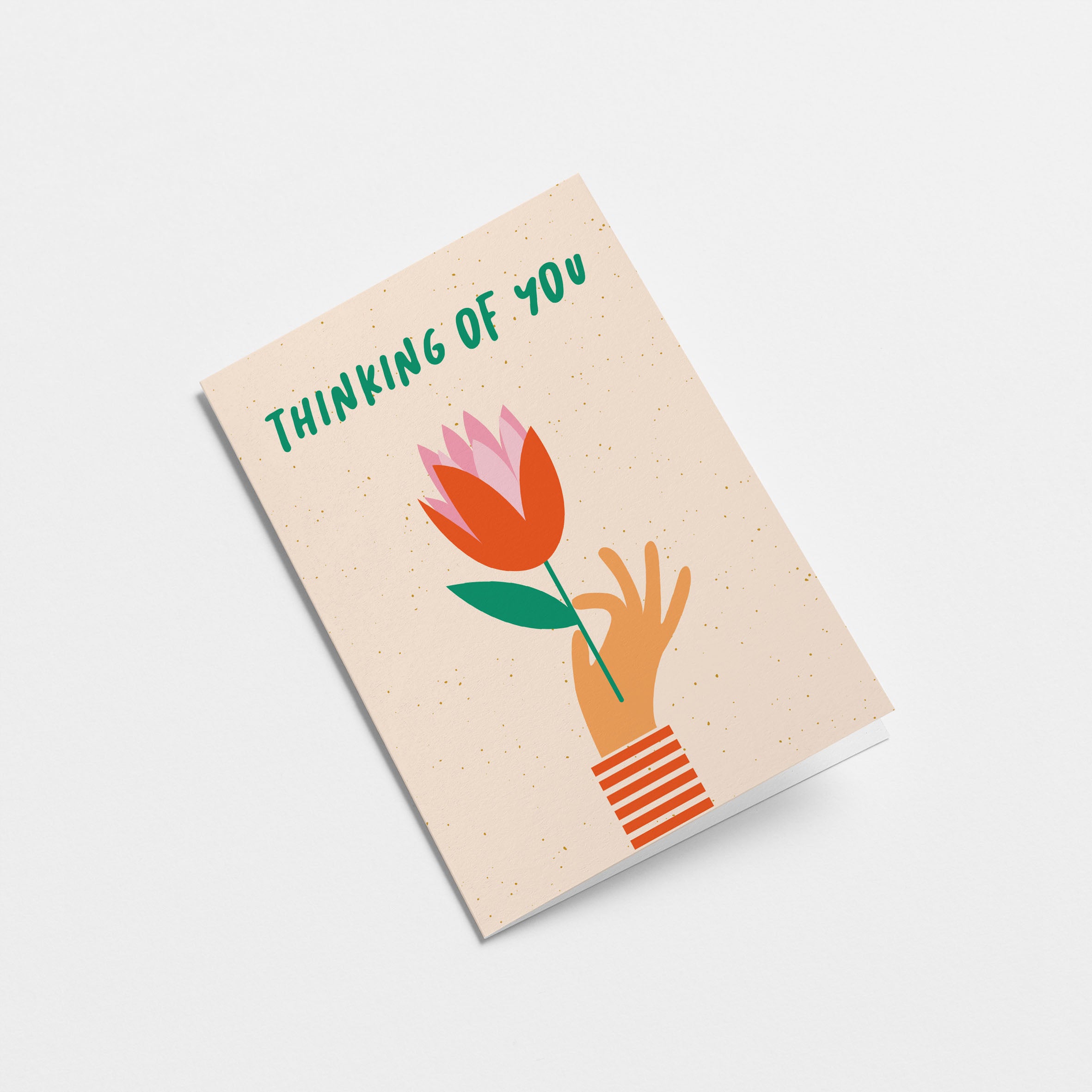 Thinking of you card with a hand holding red tulip and a text that says thinking of you Edit alt text