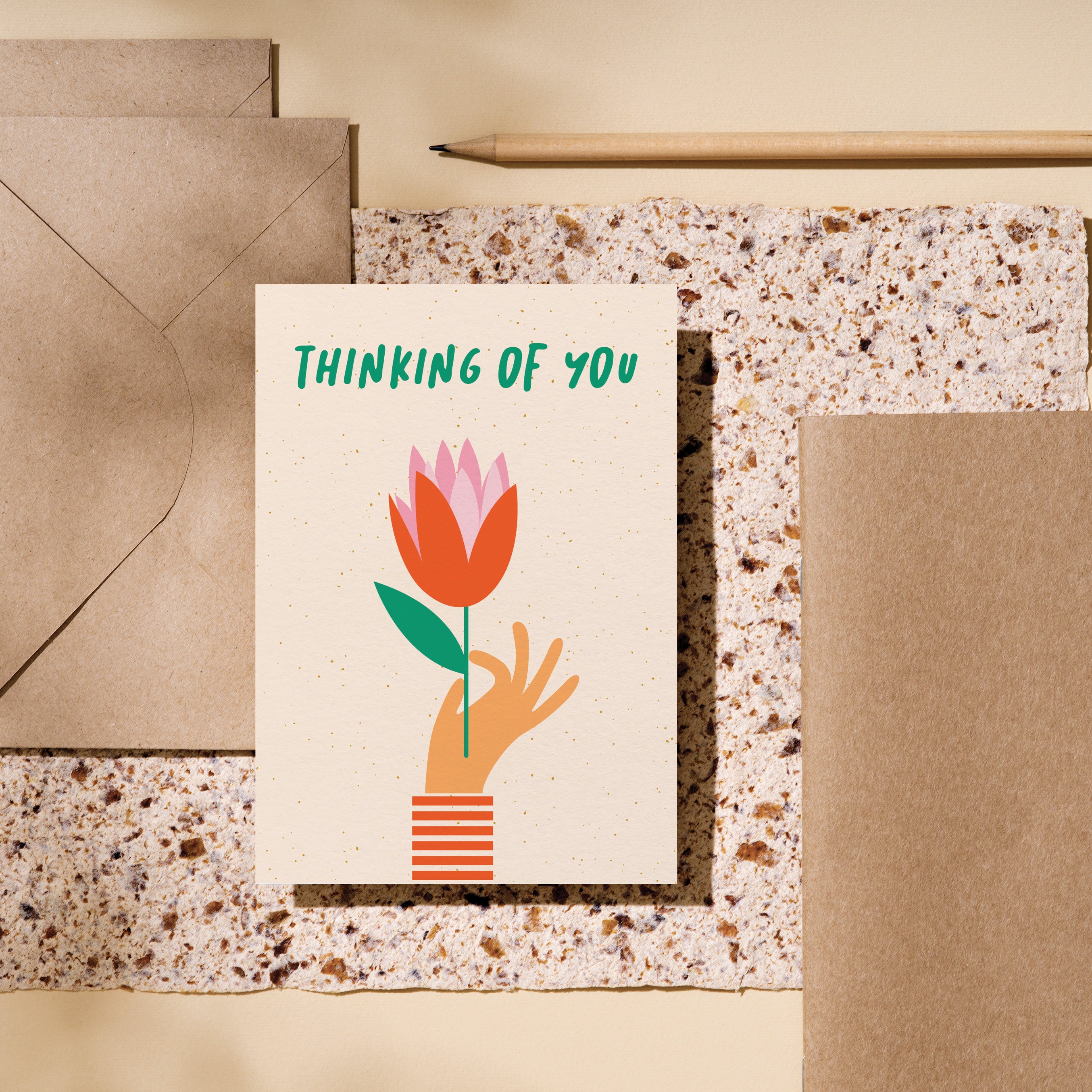 Thinking of you card with a hand holding red tulip and a text that says thinking of you Edit alt text