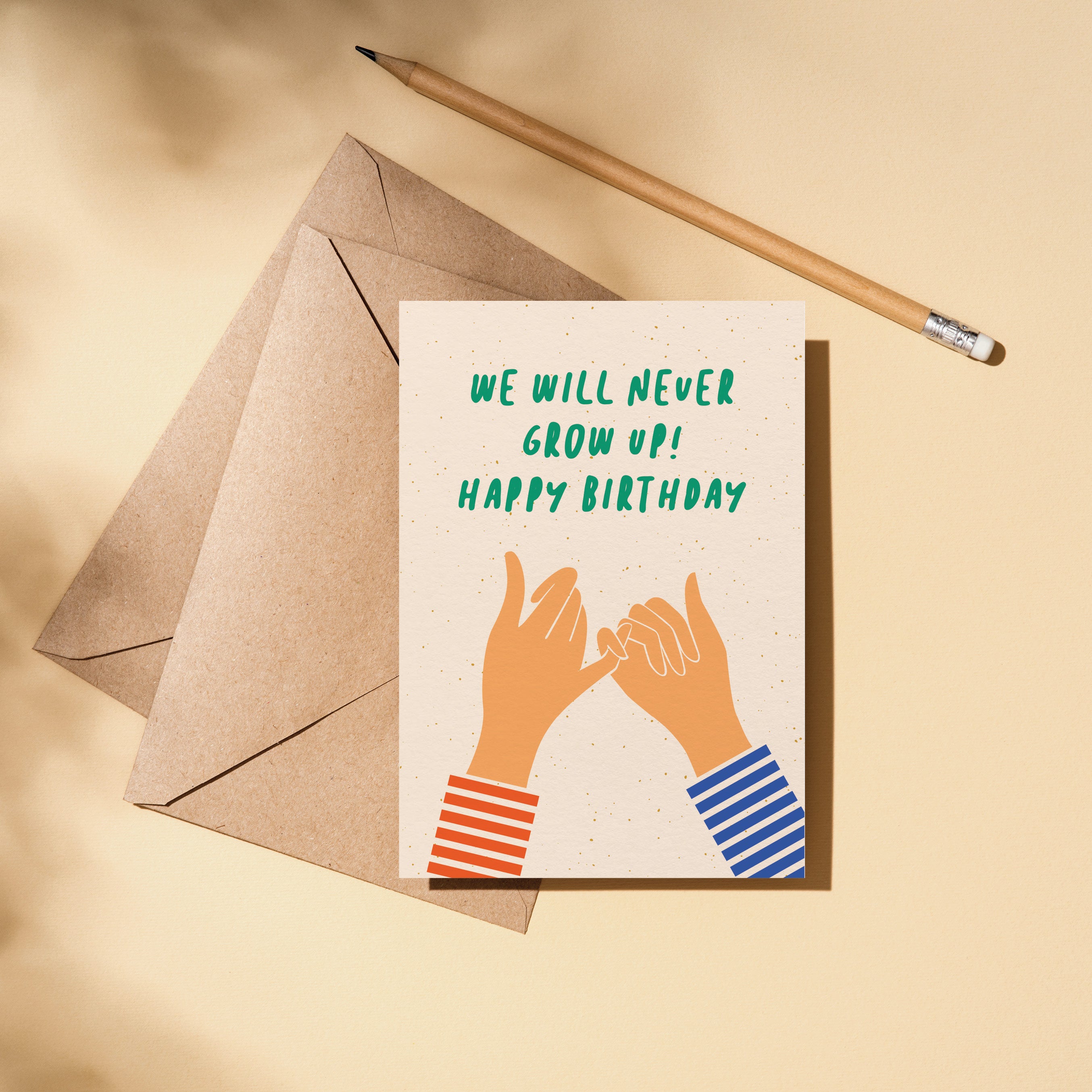 Birthday card with two hands creating gesture of promise with little fingers and a text that says we will never grow up happy birthday Edit alt text