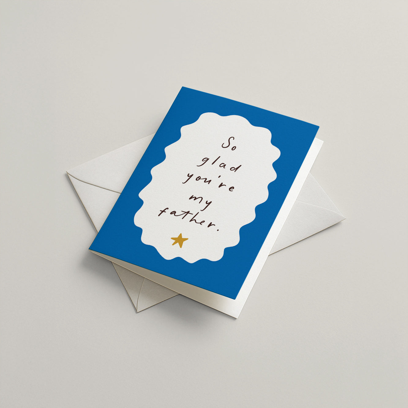 Greeting card with 'So glad you're my father' text on a blue background, with an envelope.