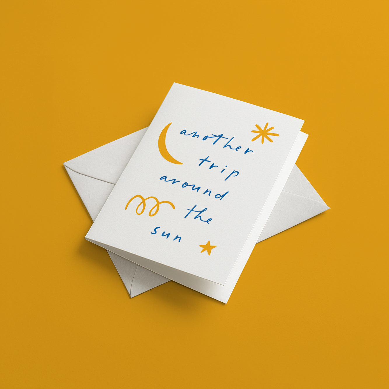 Greeting card with 'another trip around the sun' text and celestial illustrations on a yellow background