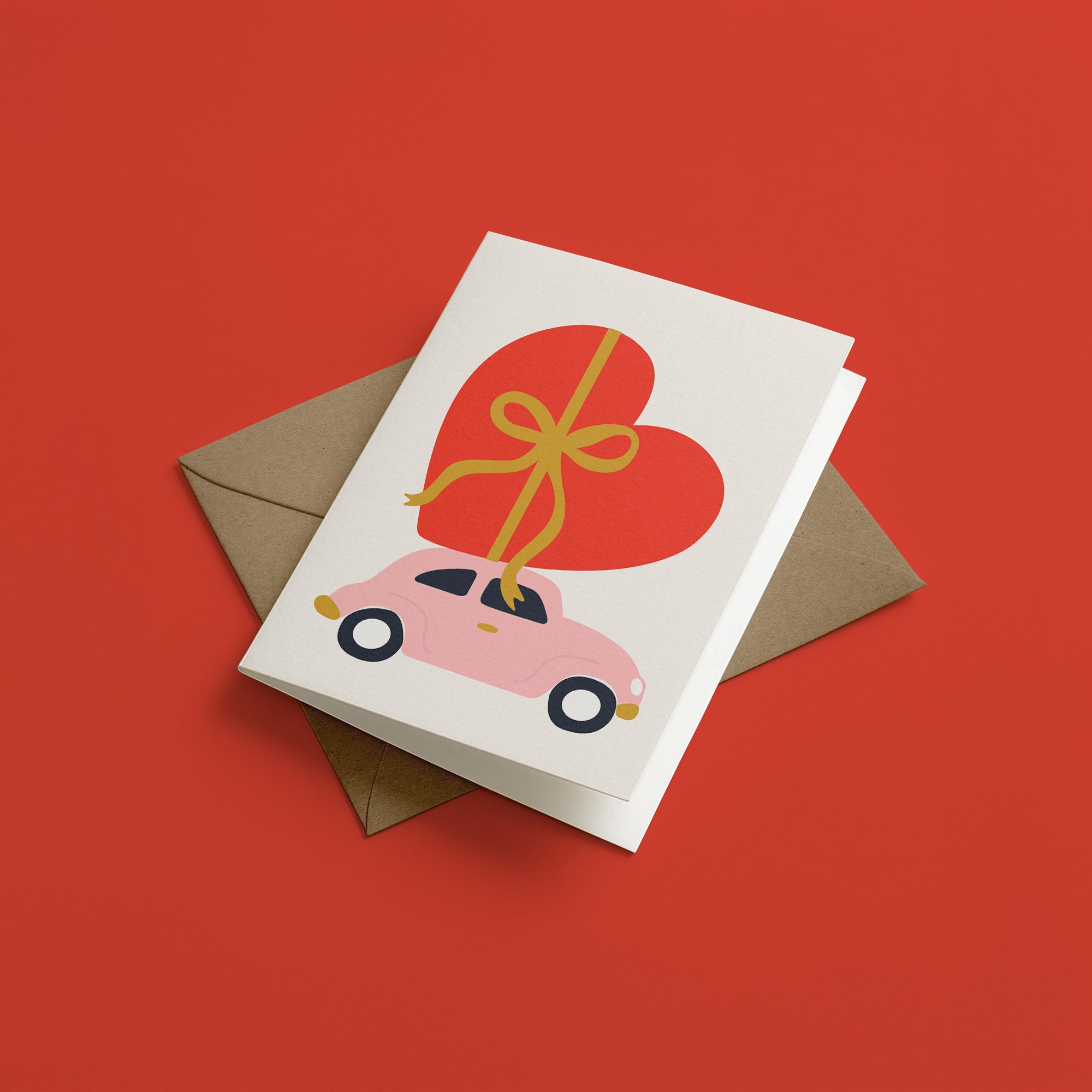 Greeting card with a pink retro car carrying a big red heart and yellow bow on a red background
