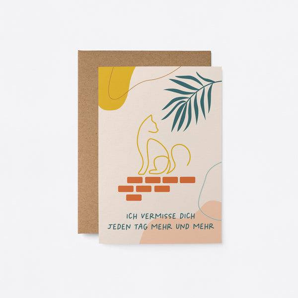 German friendship card with green leaf and a yellow cat drawing on with a text that says Ich vermisse dich jeden Tag mehr und mehr