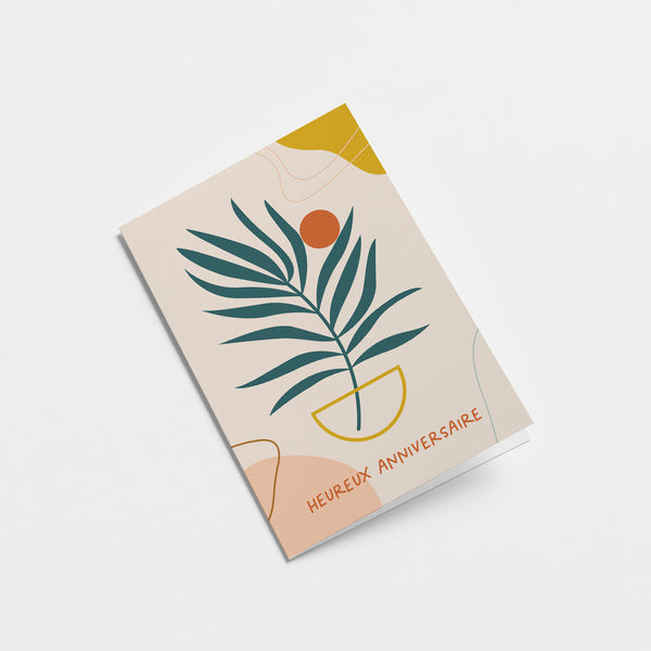 French birthday card with a green plant drawing and a orange sun figure and a text that says Heureux anniversaire