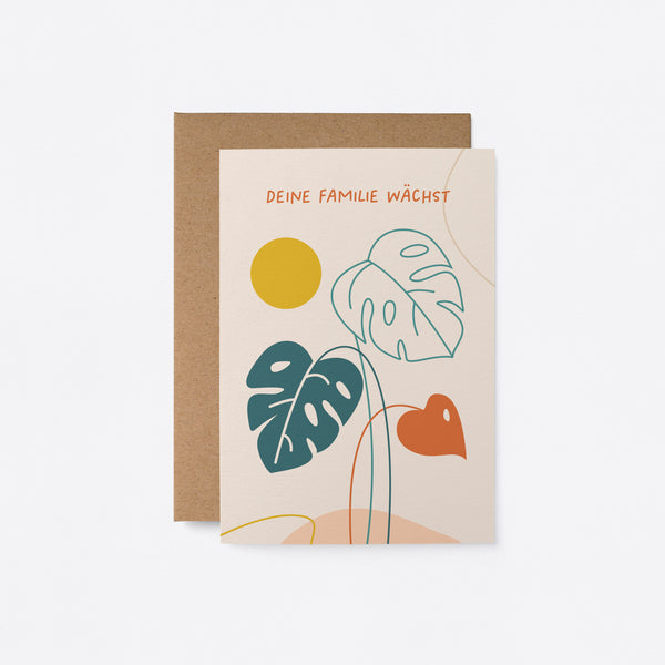 German new baby card with green leaf drawings and a little red leaf with yellow sun and a text that says Deine Familie wächst