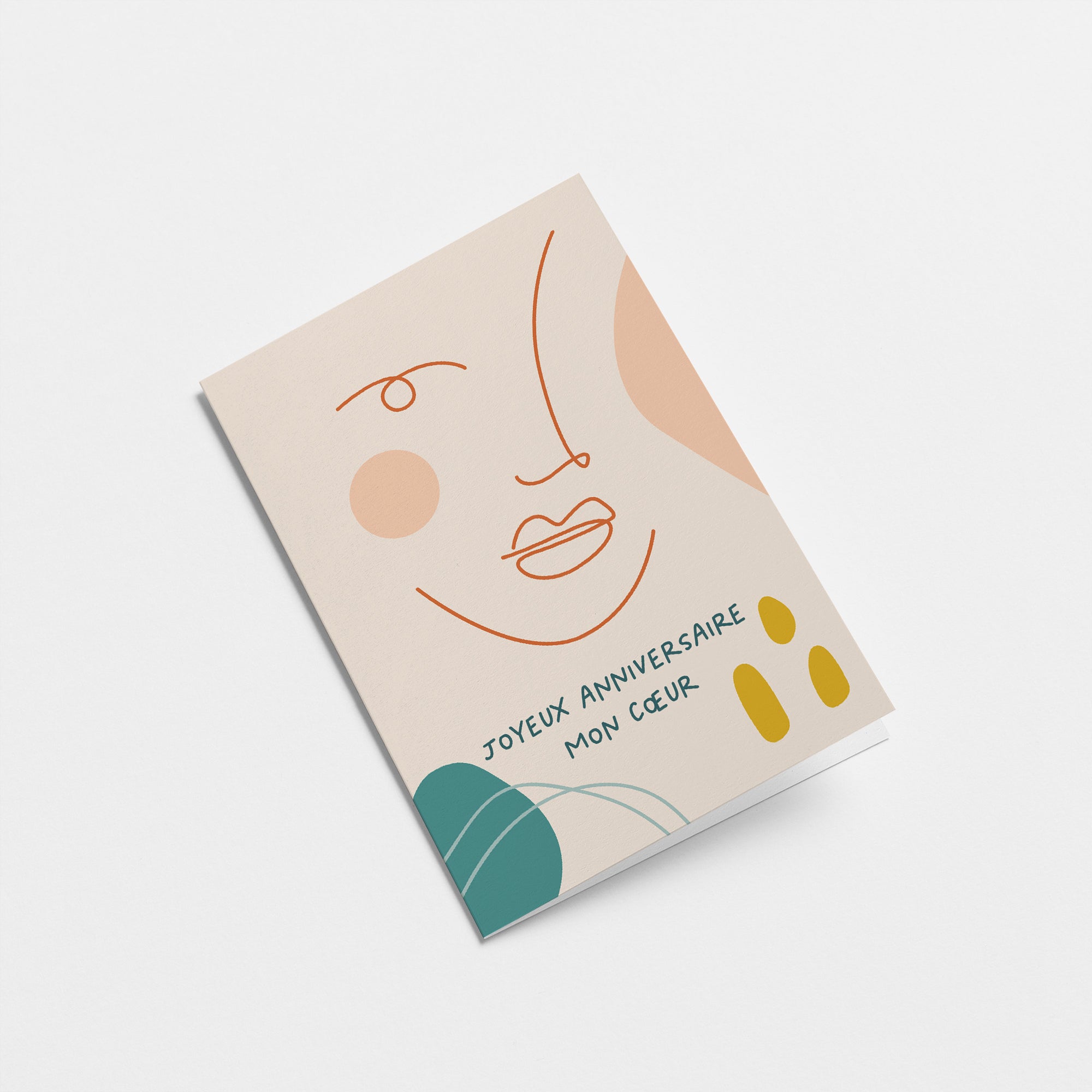 French birthday card with a woman face drawing with lines and a green leaf and a text that says Joyeux anniversaire mon cœur