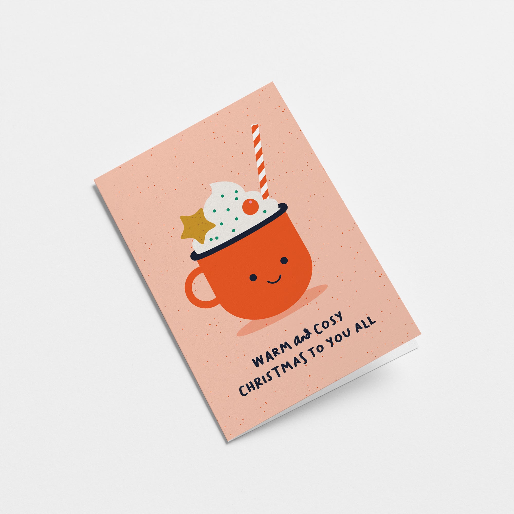 christmas card with a red cup full of white cream and decorations and a text that says warm and Cosy Christmas to you all