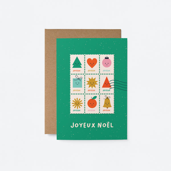 French christmas greeting card with colorful letter stamps on a green card and a text that says Joyeux Noël