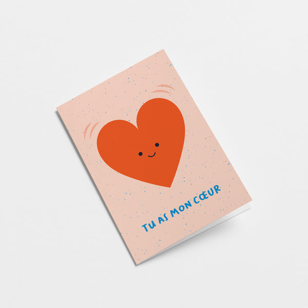 French Love card with a red heart shape with a smiley face and a text that says Tu as mon cœur  Edit alt text