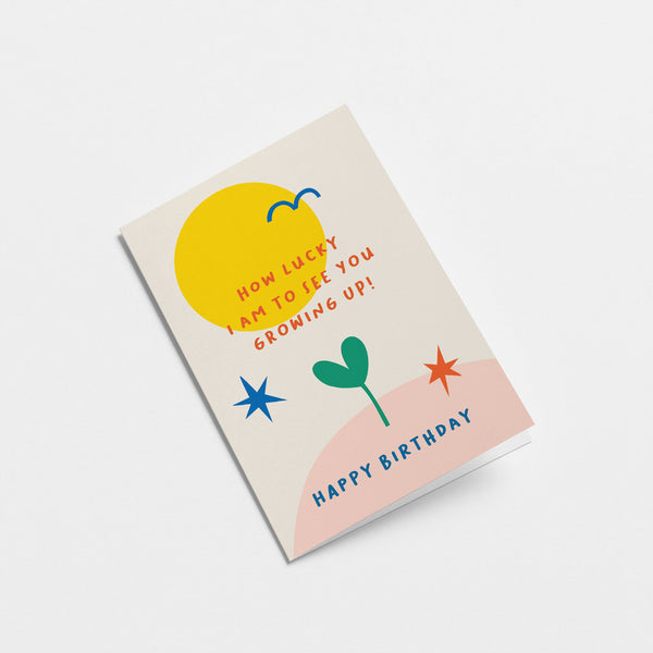 Birthday Card with yellow sun, blue bird, green plant, red and blue stars and a text that says How lucky I am to see you growing up  Edit alt text