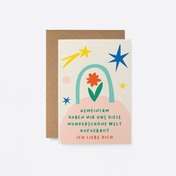 German Love card with red and green flower, blue, yellow and pink figures with a text that says Gemeinsam haben wir uns diese wunderschöne Welt aufgebaut. Ich liebe dich