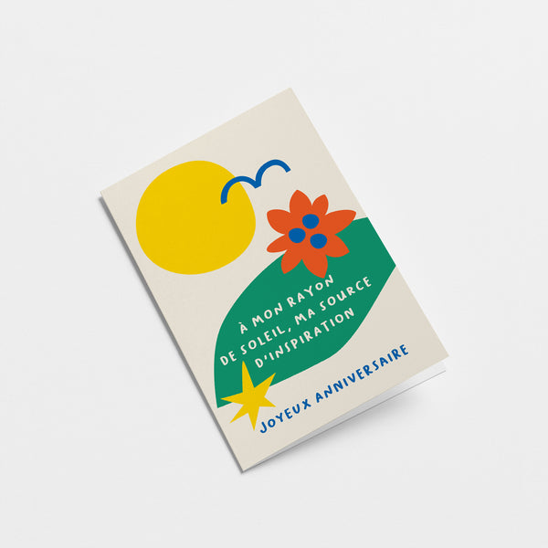 French Birthday card with yellow sun, blue bird, green, red, blue figures and a text that says À mon rayon de soleil, ma source d’inspiration. Joyeux anniversaire  Edit alt text