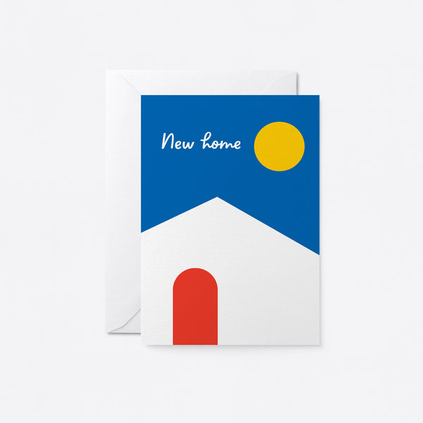 housewarming card with a white house, red door, blue sky and yellow sun and a text that says new home