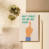 friendship card with a finger tied with a red string with a text that says don’t forget you are not alone  Edit alt text