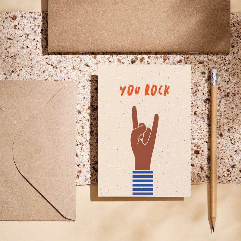 birthday card with a brown hand and a gesture of sign of the horns with a text that says you rock  Edit alt text