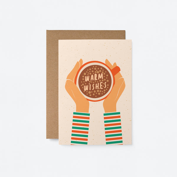 Christmas card with a cup of coffee holded by two hands from sides and a text in it that says warm wishes