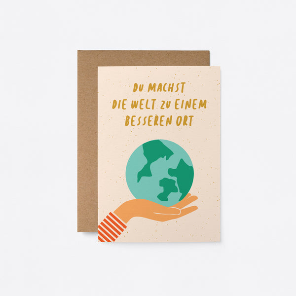German greeting card with earth on the palm of a hand with a text that says Du machst die Welt zu einem besseren Ort