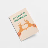 french greeting card with two hands creating heart shape with fingers and a text that says Je t’envoie des ondes positives  Edit alt text