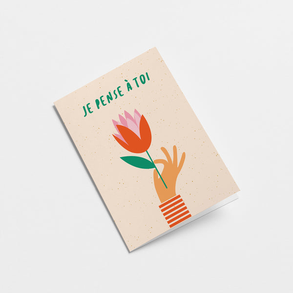 french Thinking of you card with a hand holding red tulip and a text that says Je pense à toi  Edit alt text