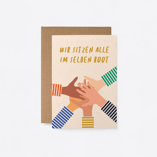 German Friendship card with five different colored hands put on top of each other and a text that says Wir sitzen alle im selben Boot