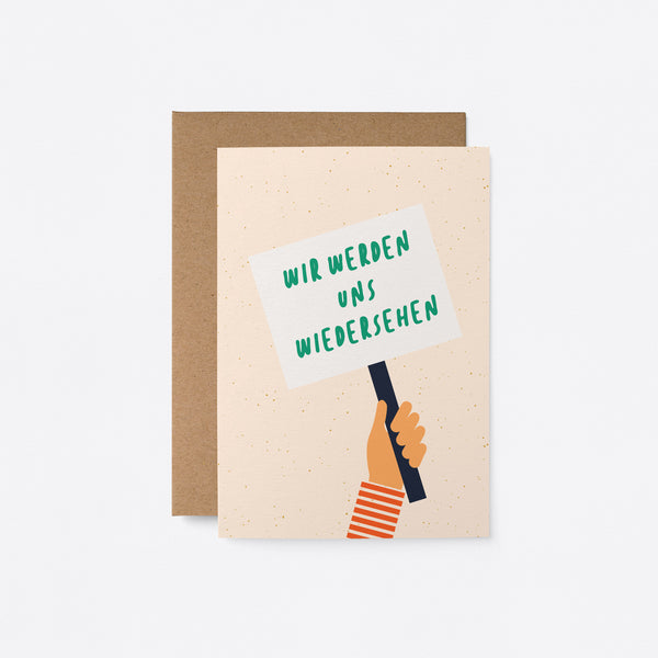 German Friendship card with a hand holding a picket sign with a text in it that says Wir werden uns wiedersehen