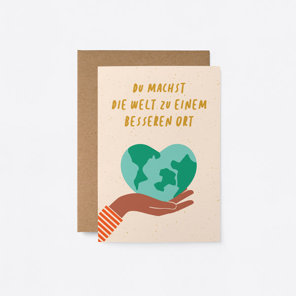 German friendship card with a heart shaped earth on the palm of a hand with a text Du machst die Welt zu einem besseren Ort
