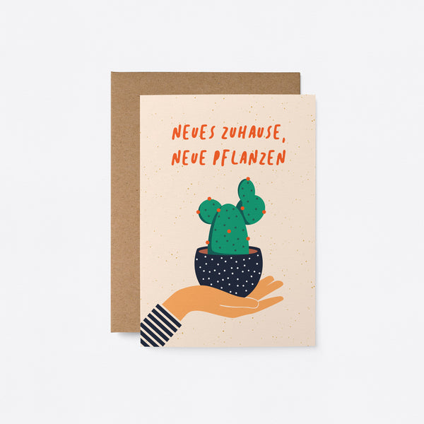 German housewarming card with a hand holding a black flowerpot with a cactus in it and a text that says Neues Zuhause, neue Pflanzen