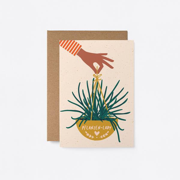 German housewarming card with a hand holding yellow plant basket with a text that says Pflanzen-Lady