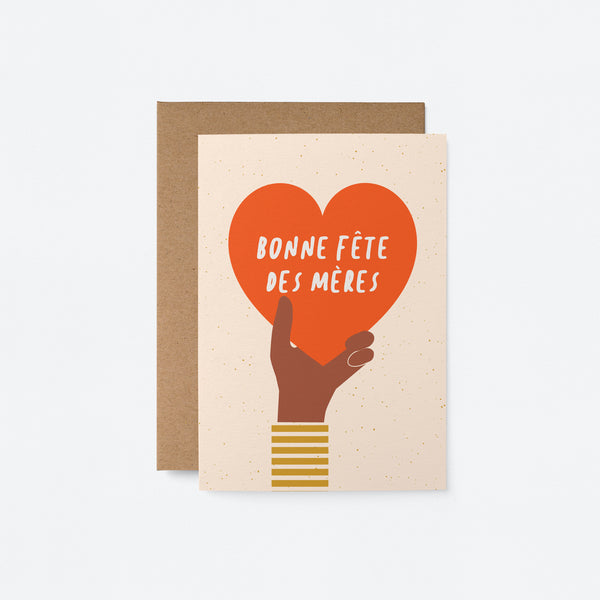 french mothers day card with a black hand holding a big red heart and a text that says Bonne fête des mères