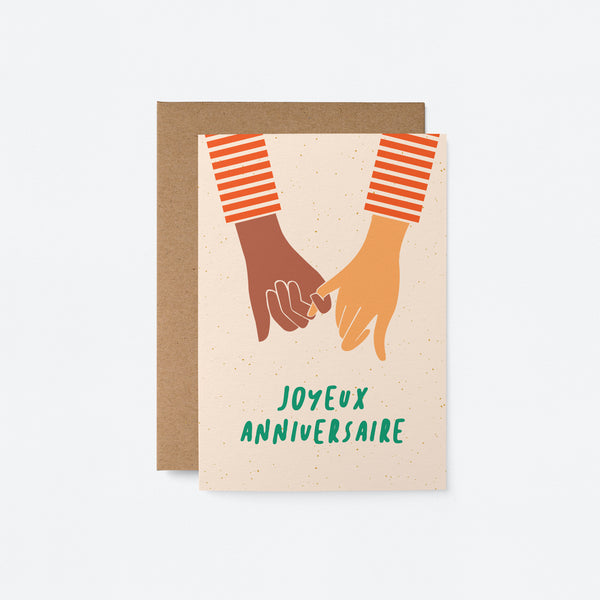 french anniversay card with a black hand and white hand holding and a text that says Joyeux anniversaire
