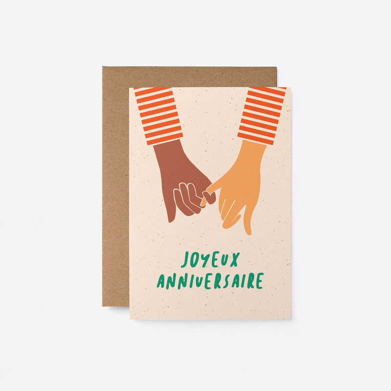 french anniversay card with a black hand and white hand holding and a text that says Joyeux anniversaire