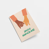 french anniversay card with a black hand and white hand holding and a text that says Joyeux anniversaire  Edit alt text