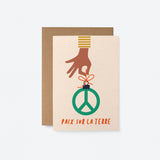 french christmas card with a black hand holding a peace figure and a text that says Paix sur la Terre