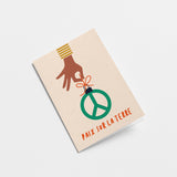 french christmas card with a black hand holding a peace figure and a text that says Paix sur la Terre  Edit alt text